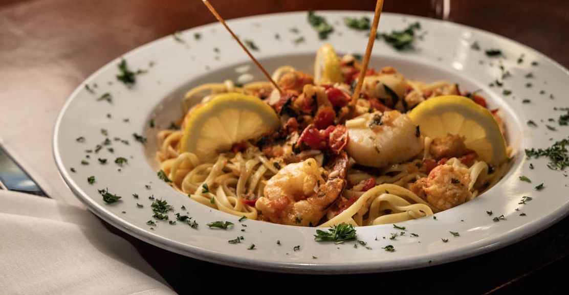 A plate of shrimp with lemon wedges, decorated with parsley for garnish