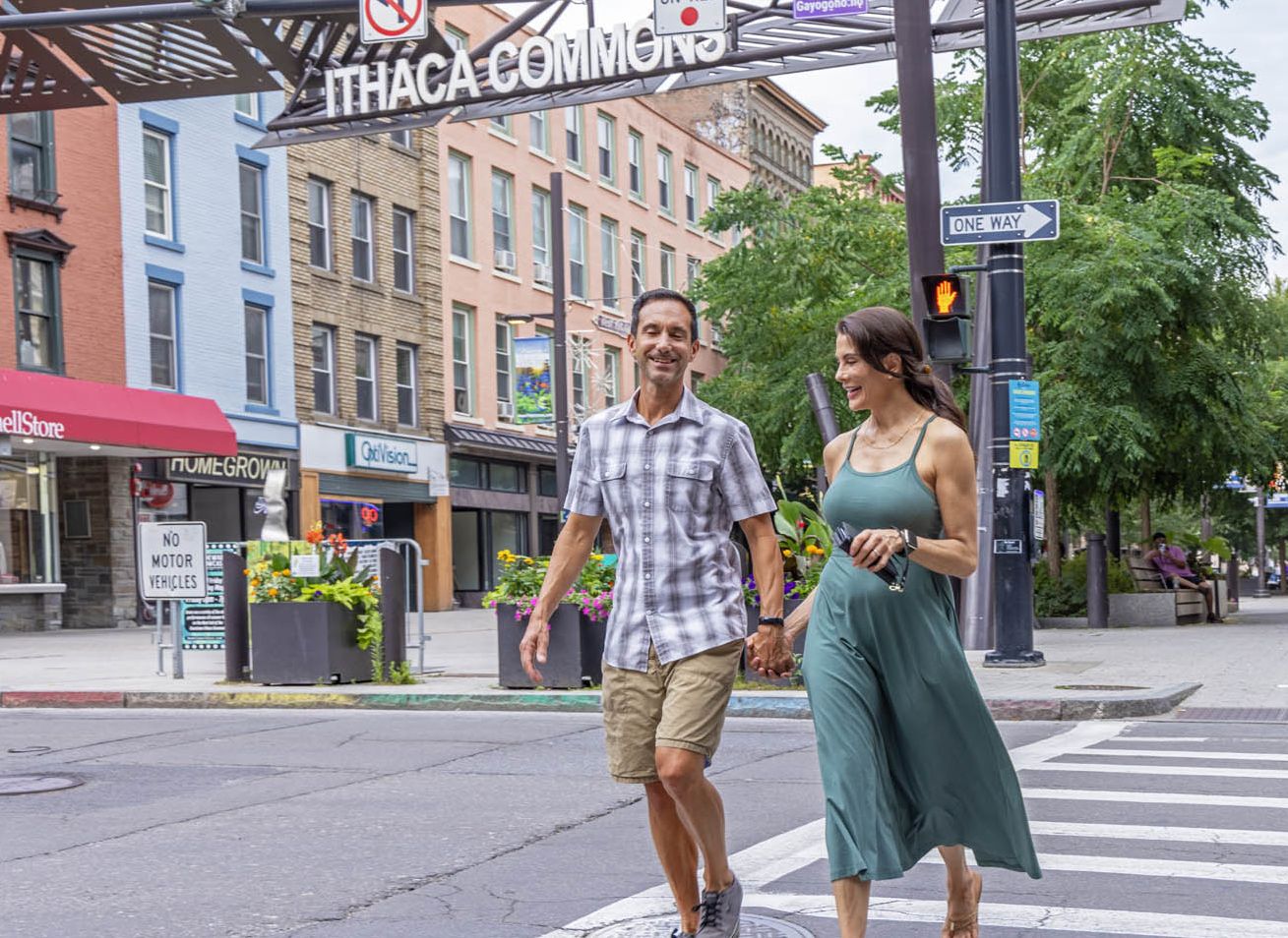 A couple crossing Cayuga Street in Ithaca Commons